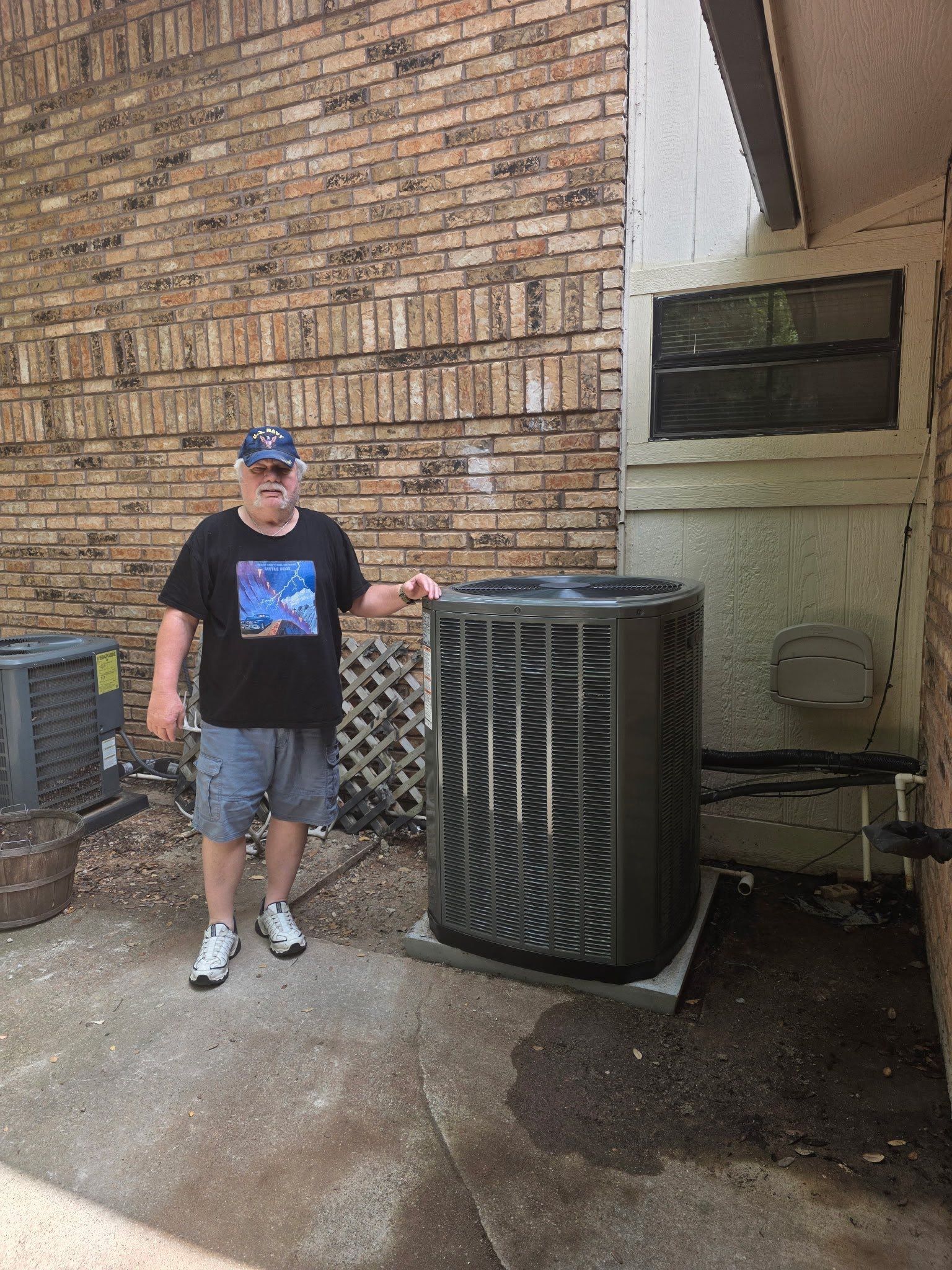 man standing next to a home air conditioning unit