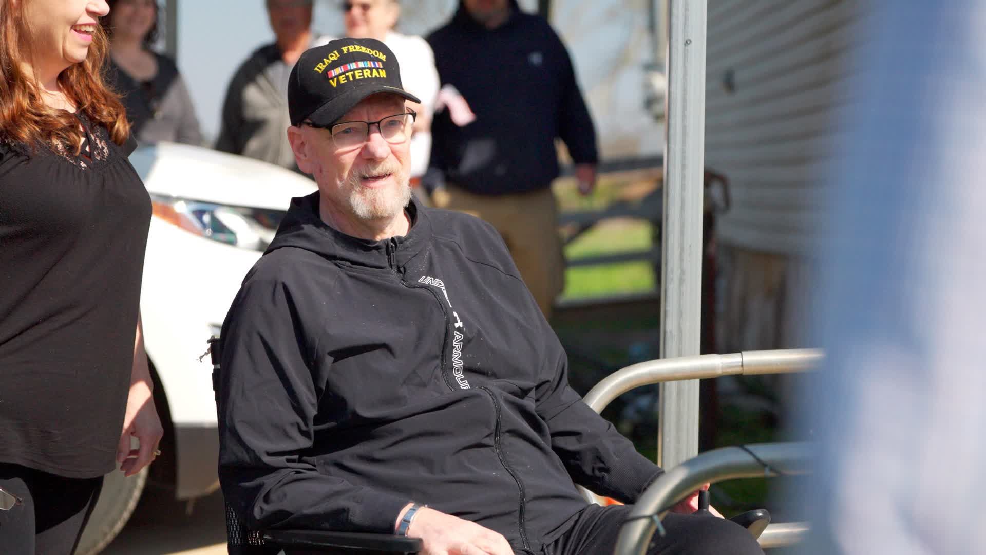 a wounded veteran in a wheelchair receiving a new home