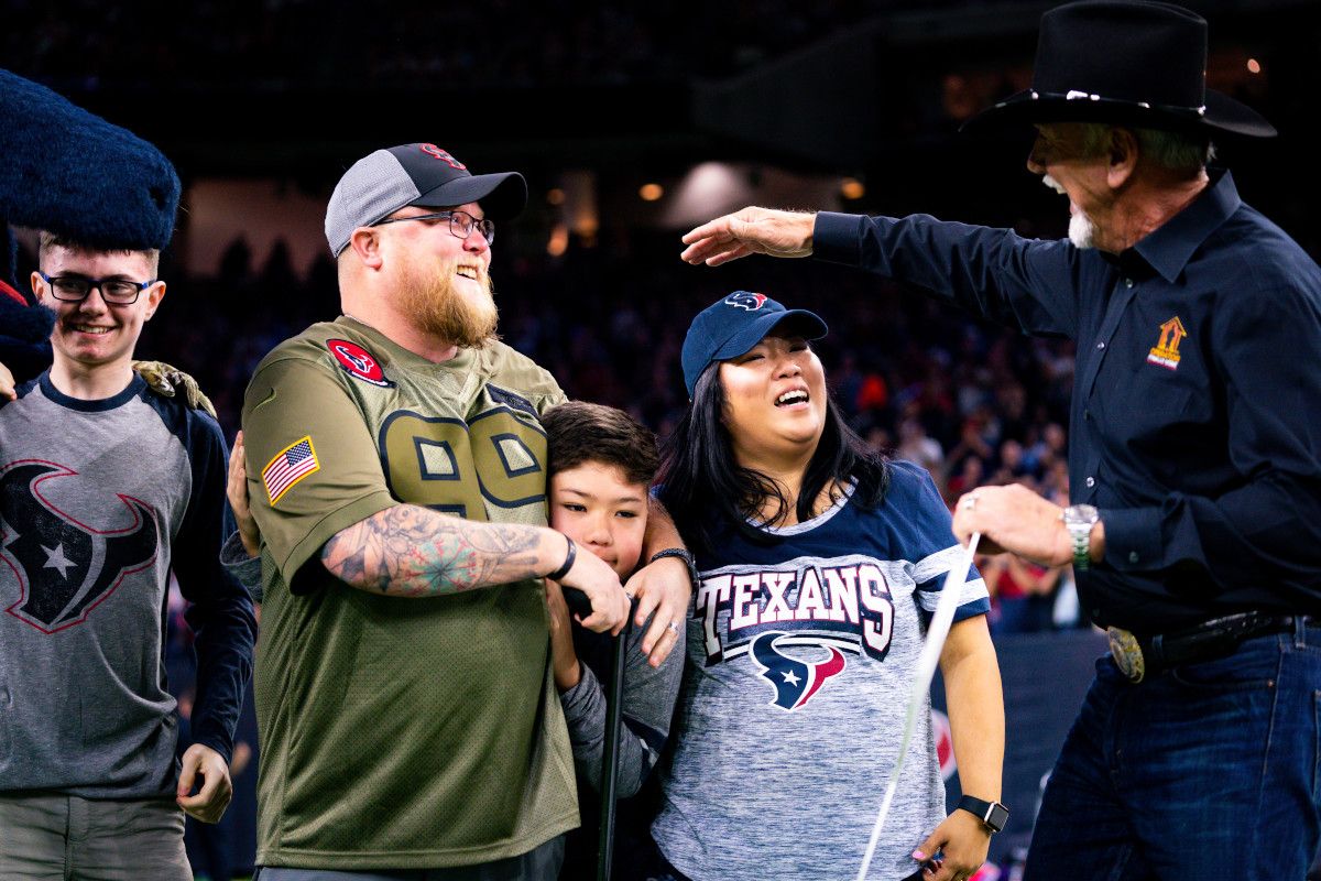 justin reuber and his family receiving an honor at a houston texans game